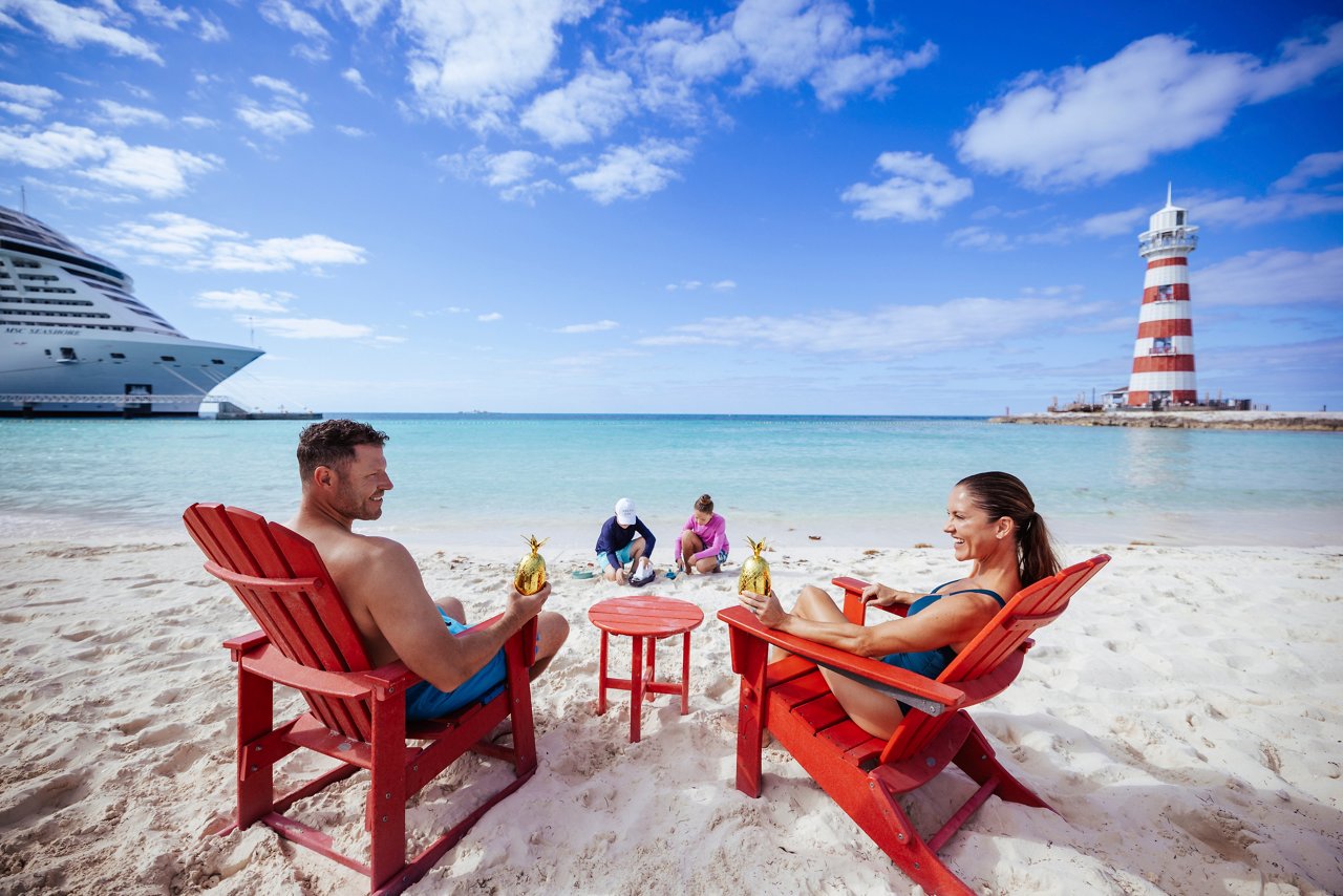 Una pareja se relaja en la playa con cócteles, disfrutando de la impresionante vista caribeña en Ocean Cay | MSC Cruceros
