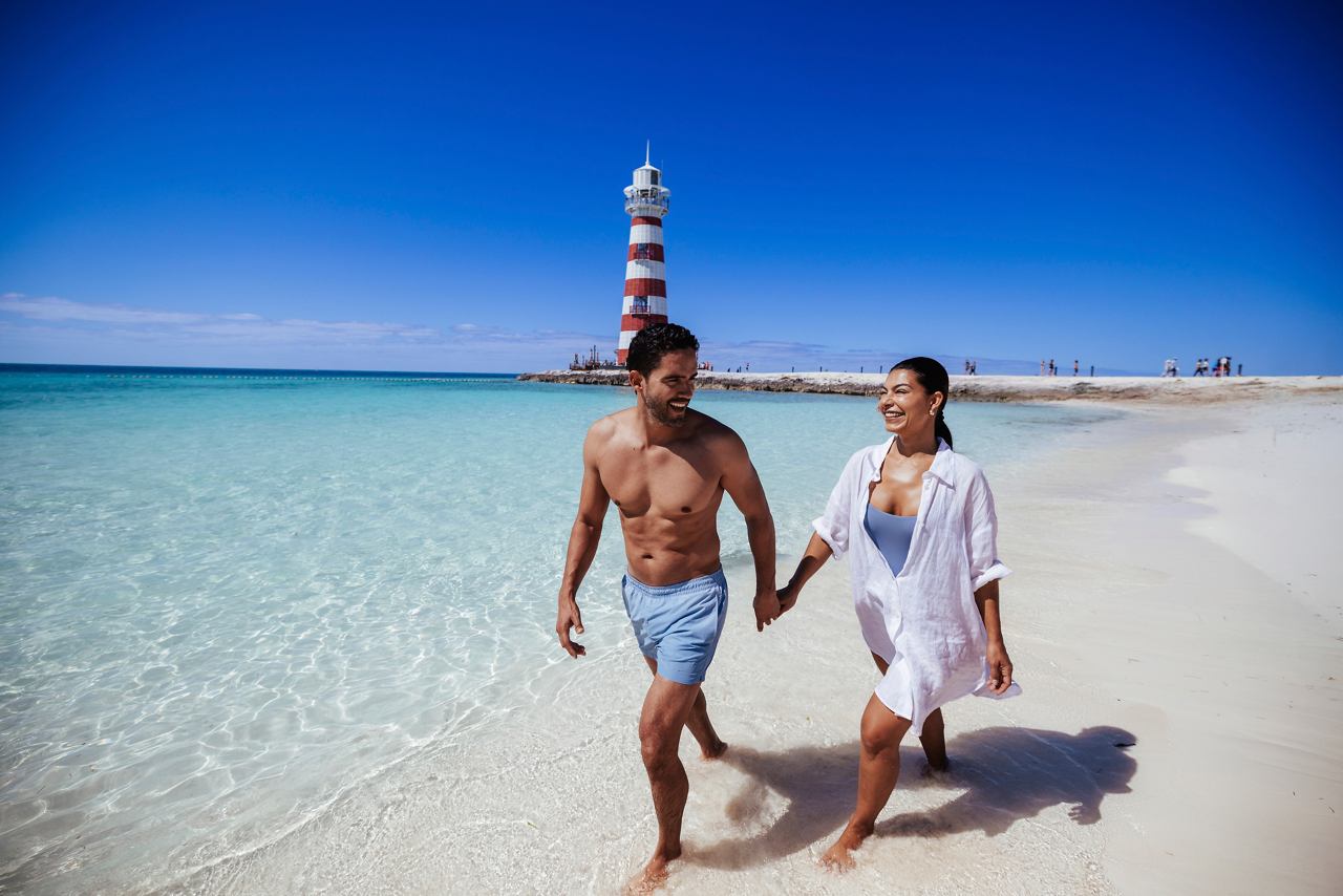 Una pareja disfruta de un paseo romántico de la mano por la playa de arena de Ocean Cay MSC Marine Reserve | MSC Cruceros