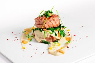 A beautifully presented dish featuring veal and spinach, served at the Lighthouse Restaurant on MSC Bellissima | MSC Cruises