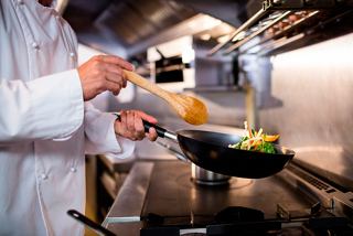 A chef skillfully prepares fresh vegetables in the kitchen aboard MSC Grandiosa | MSC Cruises