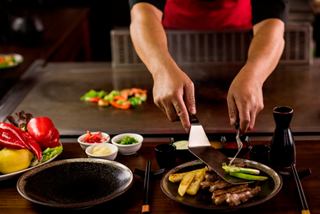 A chef skillfully prepares a colourful selection of vegetables and meat at Le Grill restaurant on MSC Euribia | MSC Cruises