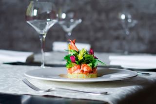 A beautifully plated seafood salad featuring crab and vibrant vegetables on a dining table | MSC Cruises