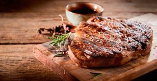 A delicious steak topped with sauce and garnished with rosemary, served in Le Grill on MSC Euribia | MSC Cruises