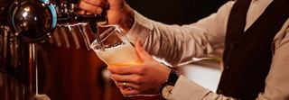 A bartender expertly pouring a refreshing draft beer at the bar on MSC Euribia | MSC Cruises