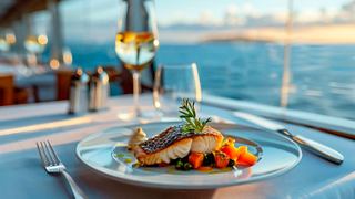 Delicious salmon dish with garnish against a sunset backdrop. | MSC Cruises