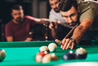 Friends enjoying a lively game of billiards at L'Olimpiade Sporting Bar on MSC Magnifica | MSC Cruises