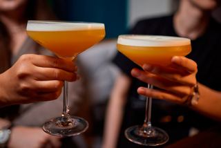 Two hands clinking cocktail glasses in a toast, celebrating moments together at L'Ametista Lounge | MSC Cruises