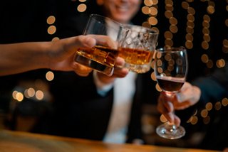 A joyful toast with glasses of different beverages shared among friends at the Tiger Bar on MSC Magnifica | MSC Cruises