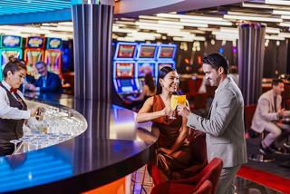 A couple enjoys cocktails at the lively bar in the MSC Signature Casino | MSC Cruises