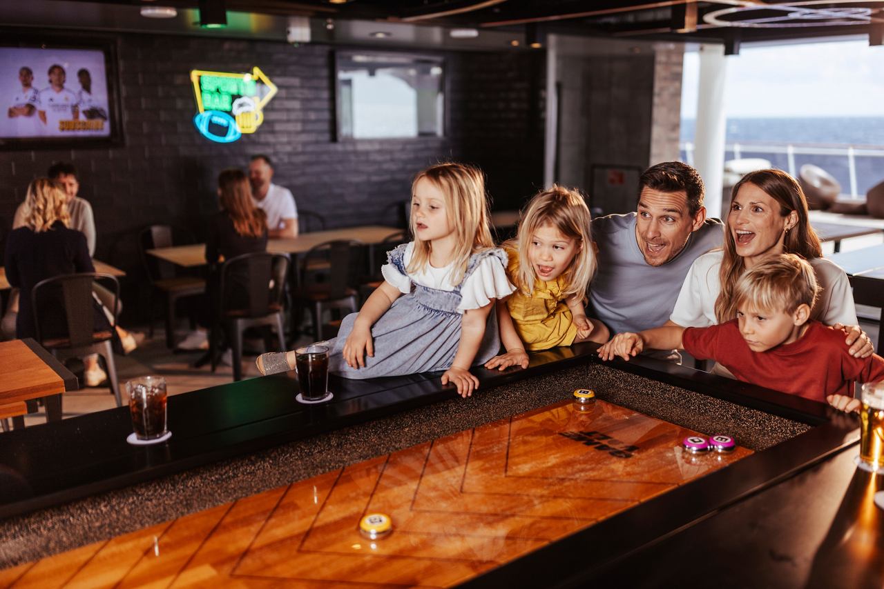 Un groupe joyeux d'amis savourant des boissons ensemble au All-Stars Sports Bar à bord | MSC Croisières