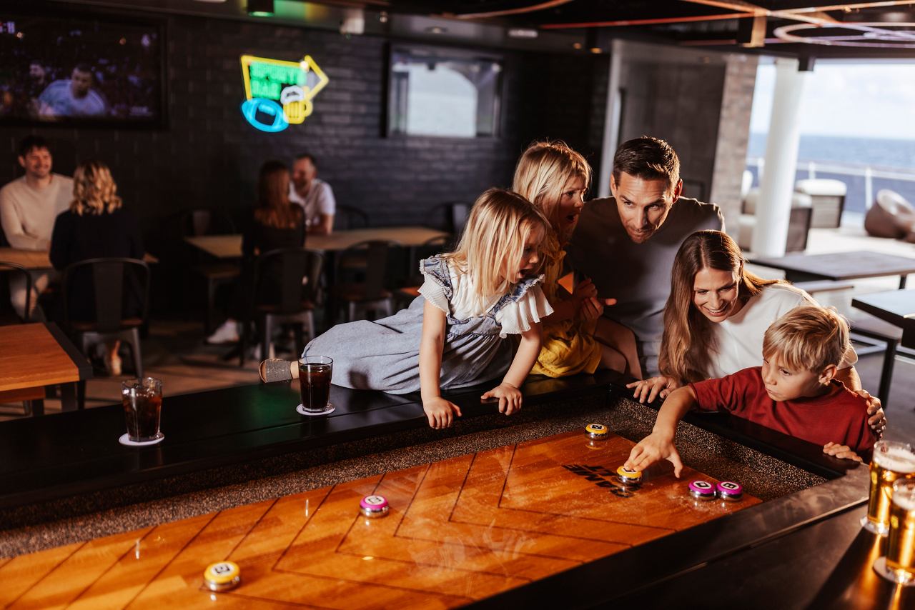 Une famille s'amuse à jouer au All-Stars Sports Bar à bord du MSC World America | MSC Croisières