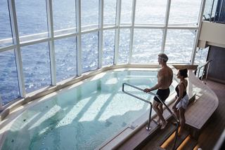 Una coppia si rilassa in una vasca idromassaggio circondata da una vista panoramica sul mare a bordo di MSC World America | MSC Crociere