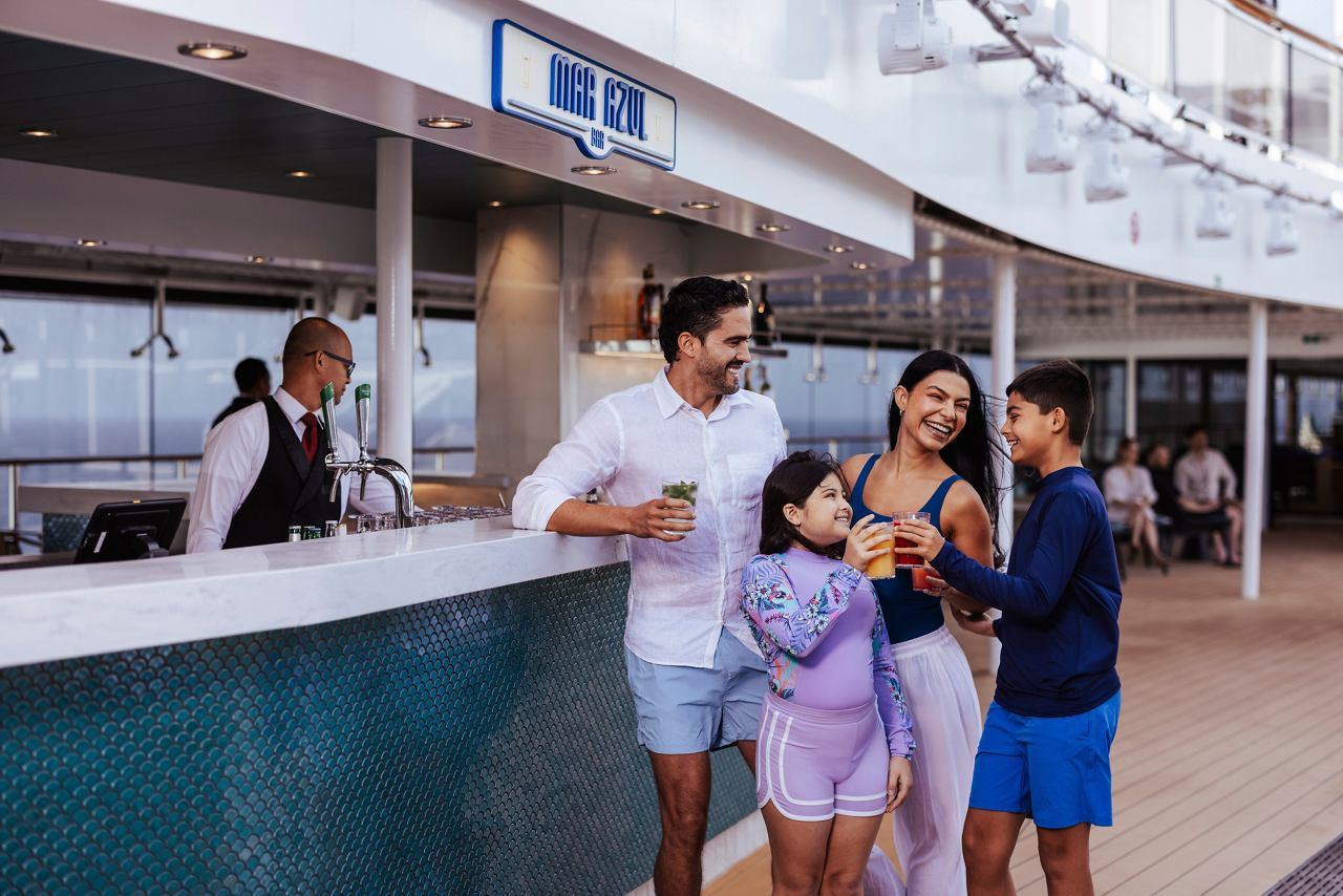 A family enjoying soft drinks together at the bar on the deck of MSC World America | MSC Cruises