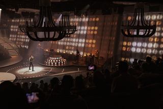 A captivating live performance with a singer on stage, surrounded by an engaged audience in a vibrant atmosphere | MSC Cruises
