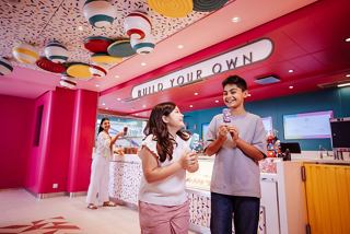 A family enjoys creating their own ice cream treats in a vibrant lounge aboard MSC World America | MSC Cruises