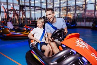 A father and son enjoying a fun ride together in bumper cars at MSC Sportplex | MSC Cruises