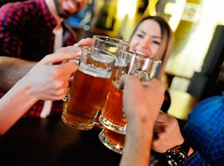 Cheers to friendship with raised beer mugs in a lively pub atmosphere | MSC Cruises
