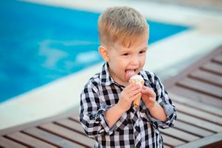 A joyful child enjoys ice cream by the pool on MSC Meraviglia, capturing a delightful moment at Polar Bar | MSC Cruises