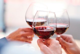 Friends toasting with glasses of red wine, celebrating special moments together | MSC Cruises