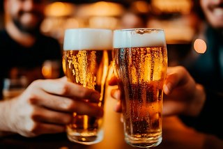 Cheers to friendship with clinking beer glasses in a warm, inviting setting | MSC Cruises