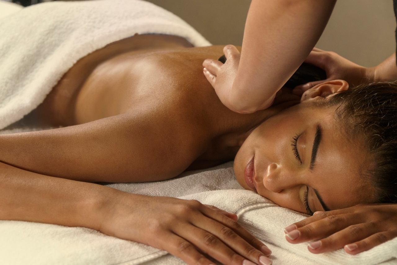A woman enjoys a relaxing lava hot stone body massage at MSC Aurea Spa | MSC Cruises