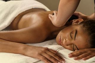 A woman enjoys a relaxing lava hot stone body massage at MSC Aurea Spa | MSC Cruises