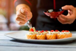 A chef garnishing sushi rolls with caviar at Kaito Sushi Bar on MSC World Europa | MSC Cruises