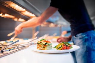 Sirviendo deliciosos platos del bufé, incluidos vegetales y lasaña | MSC Cruceros