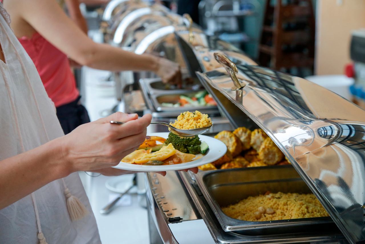 A guest serving food from the buffet at Il Mercato on MSC World Europa | MSC Cruises