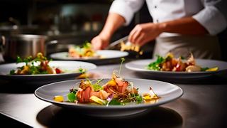 A chef carefully plating gourmet dishes in Les Dunes Restaurant on MSC World Europa | MSC Cruises