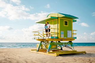 Ein lebhafter Rettungsturm steht an einem Sandstrand in Miami, mit dem Ozean und dem Himmel im Hintergrund | MSC Cruises
