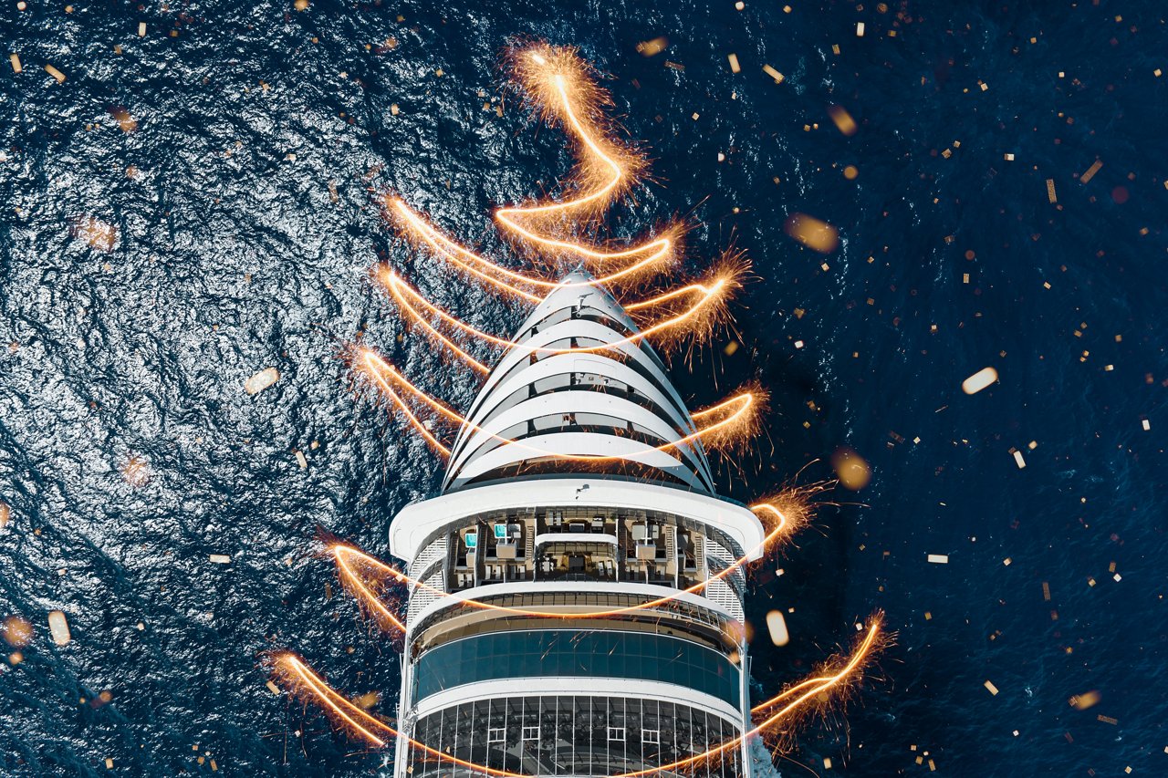 Aerial view of MSC World Europa with festive lights illuminating the ship's prow | MSC Cruises