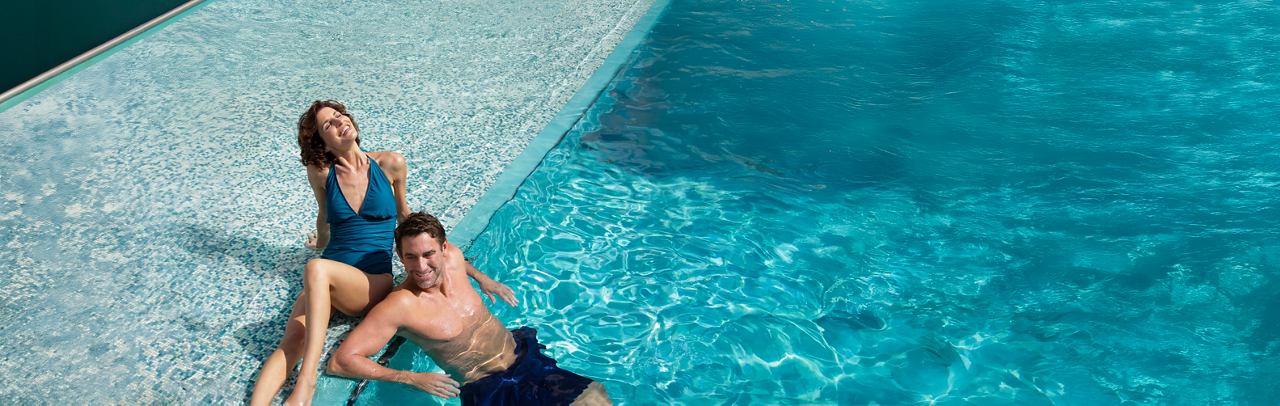 Un couple profite de leur temps au bord de la piscine dans MSC Yacht Club | MSC Croisières