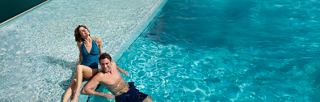 Un couple profite de leur temps au bord de la piscine dans MSC Yacht Club | MSC Croisières