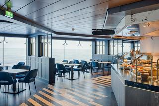 Comedor moderno con asientos cómodos y grandes ventanales que ofrecen vistas al mar | MSC Cruceros