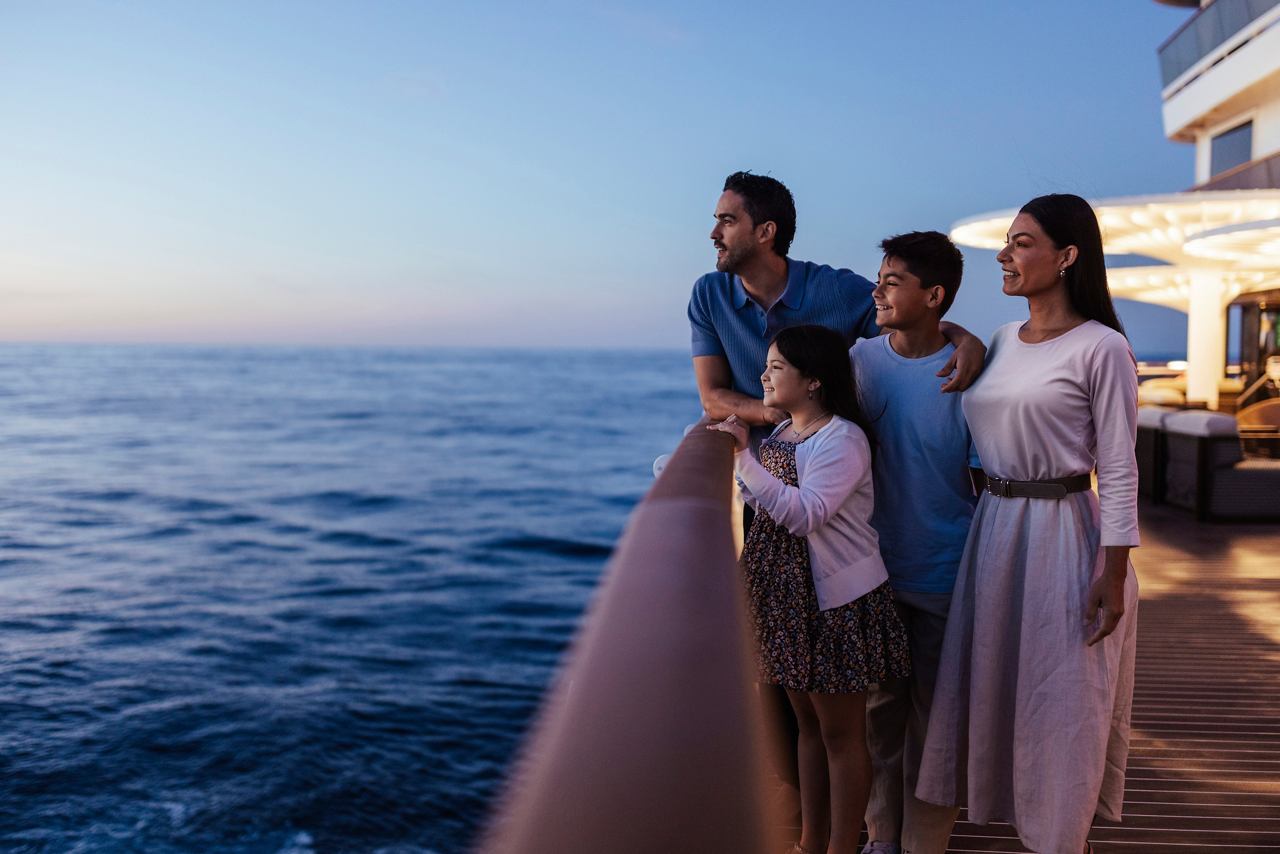 A family enjoys the sunset from the deck of a cruise ship | MSC Cruises