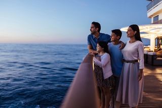 A family enjoys the sunrise over the sea from the ship's deck | MSC Cruises