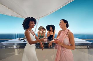 Zwei Frauen und ein Baby lächeln auf dem Deck eines Kreuzfahrtschiffs mit Meerblick | MSC Cruises