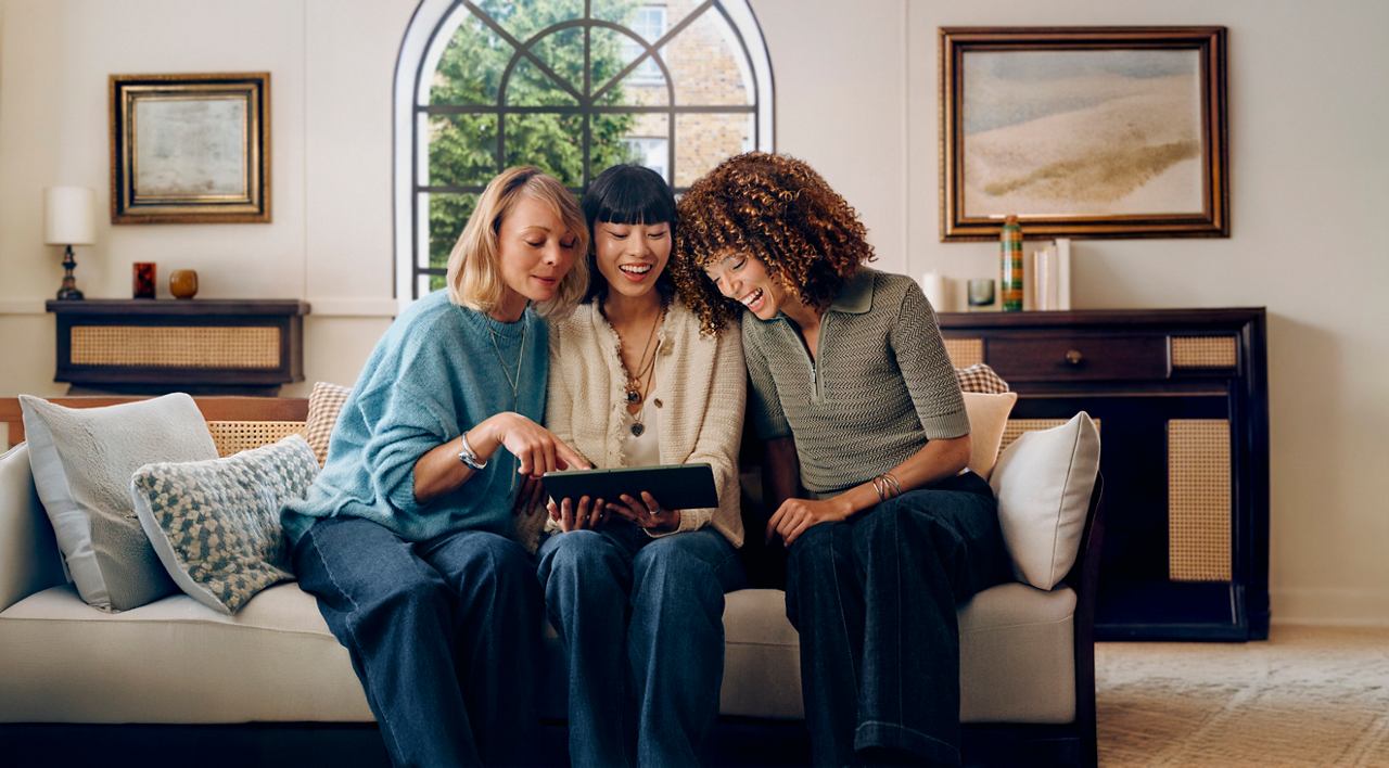 Tre amici trascorrono del tempo insieme, guardando un tablet in una casa accogliente | MSC Crociere