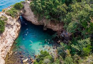Mar azul cristalino rodeado de vegetación y rocas en Italia | MSC Cruceros