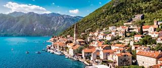 View of the stunning Kotor Bay with colorful buildings and lush greenery along the coast | MSC Cruises