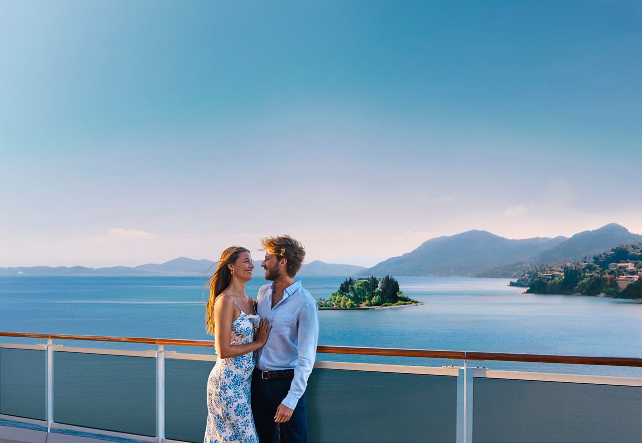 A couple embraces on the deck with a sea view in Greece | MSC Cruises