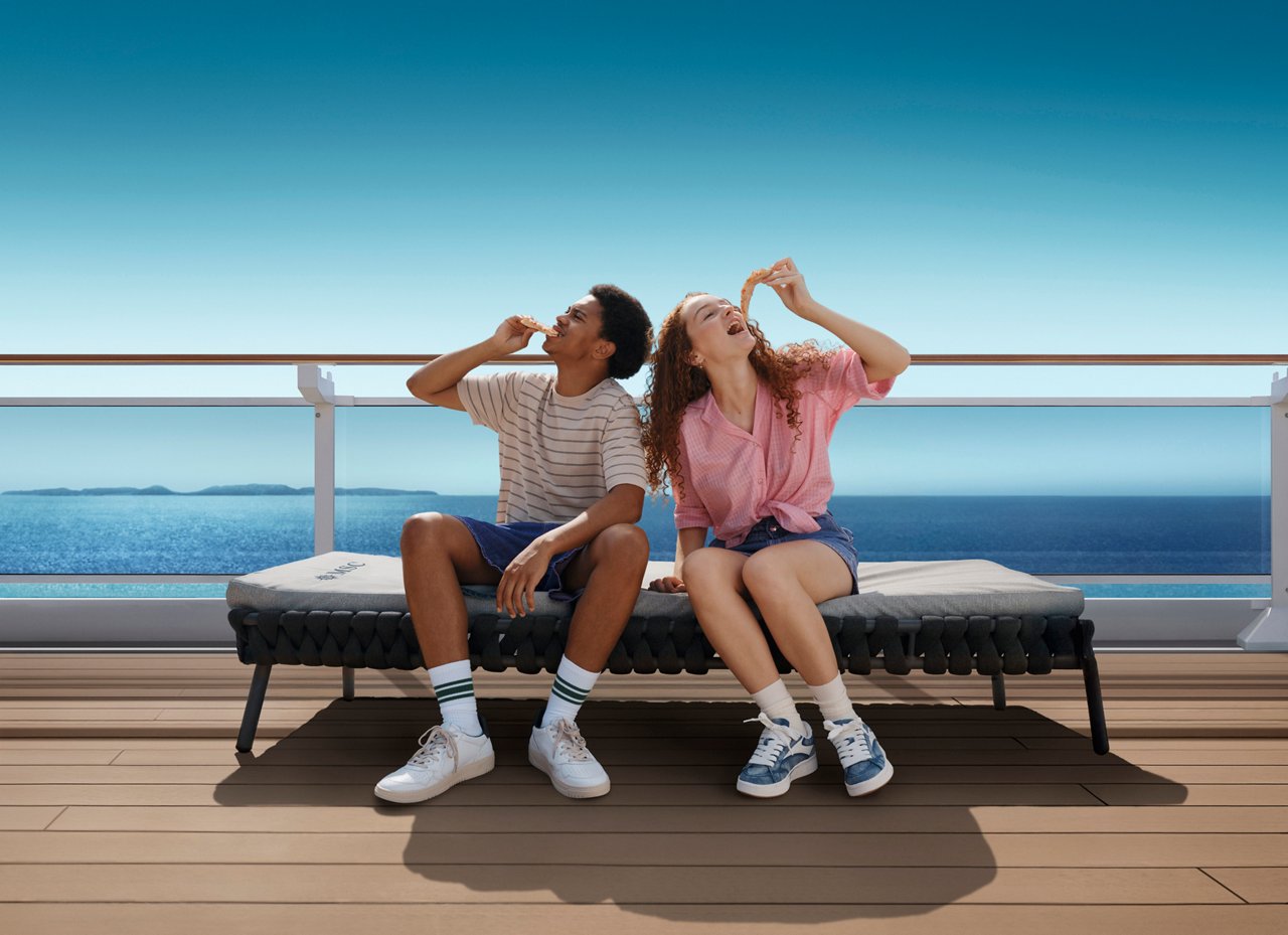 Two friends enjoy the sun on a cruise deck with a beautiful sea view in the background | MSC Cruises
