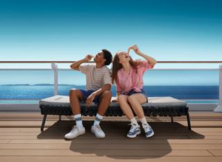 Two friends enjoy the sun on a cruise deck with a beautiful sea view in the background | MSC Cruises