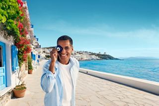 Man talking on the phone at a seaside promenade with beautiful flowers and blue sea | MSC Cruises