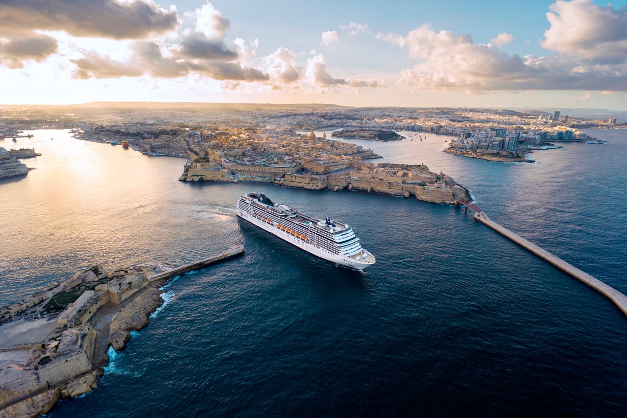 The MSC Magnifica ship sails through calm waters with beautiful clouds in the sky | MSC Cruises