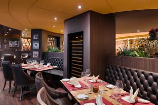 Moderna área de comedor con mesas y sillas a bordo del MSC Magnifica, perfecta para disfrutar de una comida | MSC Cruceros