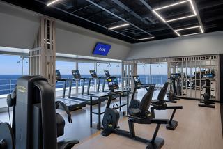 Salle de gym moderne avec équipements et vue sur la mer | MSC Croisières