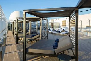 Espace de détente sur le pont du MSC Magnifica avec des chaises longues et des tables, baigné de soleil | MSC Croisières