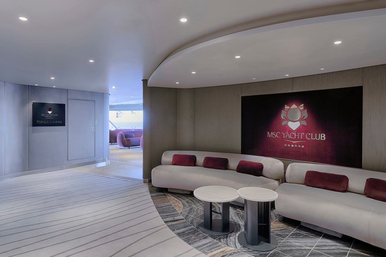 Contemporary reception area with a cozy sofa in MSC Yacht Club | MSC Cruises